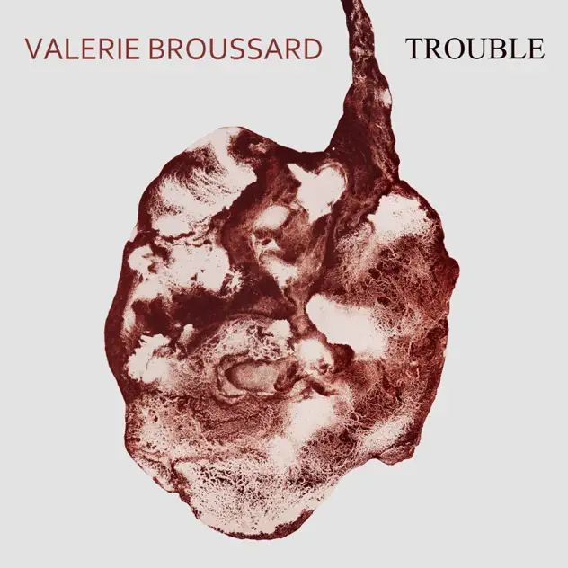 Album cover for Valerie Broussard's single Trouble. A dark red anatomical heart is depicted on the cover with swirls of red and white. The artist's name is in red and the song's title is in black.