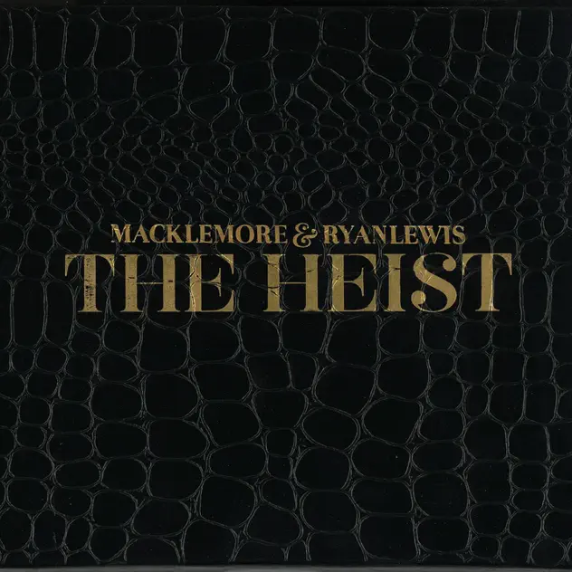 Album cover for The Heist by Macklemore and Ryan Lewis. The cover's background is cracked black leather and the title and artists' names are written in fancy gold font.