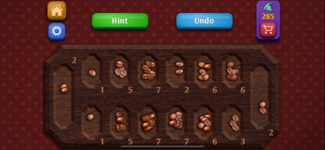 Mancala. - Sumérgete en un entorno relajante con este diseño de café, donde los granos de café sustituyen a las fichas y el tablero evoca la textura de la madera oscura.