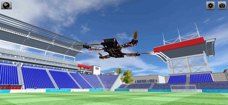 DRS - Drone Flight Simulator - O drone é visto em voo dentro de um estádio de futebol, evidenciando as amplas arquibancadas e o campo, um local perfeito para praticar corridas ou freestyle em grande escala.