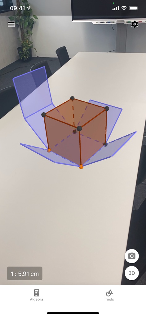 GeoGebra Calculator Suite - Esta herramienta ofrece una experiencia inmersiva con Realidad Aumentada (AR), proyectando un objeto 3D (un cubo desplegado) sobre una superficie real y mostrando medidas como '1: 5.91 cm'.