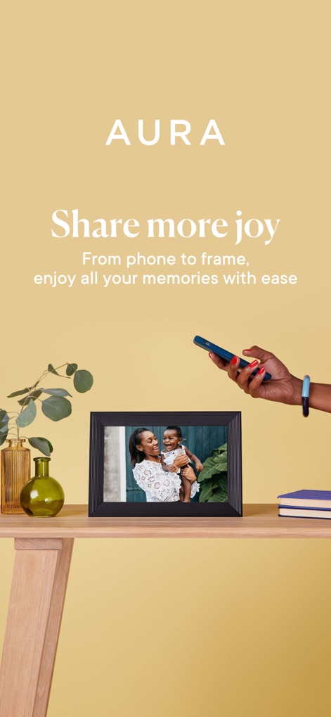 Aura Frames - Dieses Bild zeigt den digitalen Bilderrahmen Aura Frames, der ein emotionales Familienfoto anzeigt, während ein Smartphone für die einfache Einrichtung daneben platziert ist.