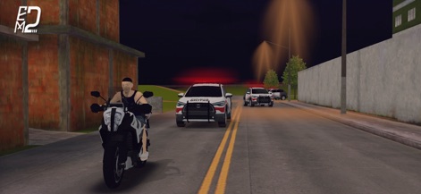 Elite Motos 2 - La aplicación muestra la tensión de una persecución policial nocturna con vehículos de emergencia en acción y un entorno urbano detallado.