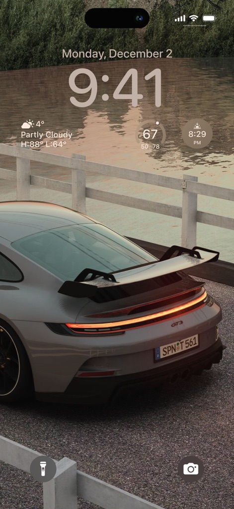 Cool Aesthetic Wallpapers 4K - La aplicación presenta fondos de pantalla con un enfoque en el diseño automotriz premium, mostrando la vista trasera de un Porsche gris junto a un sereno entorno acuático.