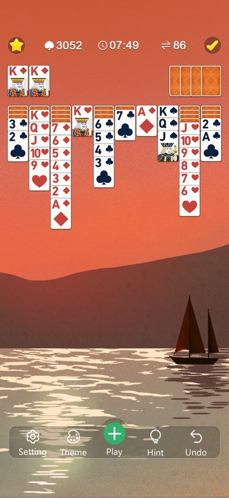 Classic Spider Solitaire Mania - Experience a calming atmosphere with beautiful background themes, such as the tranquil sunset ocean scene with a sailboat, perfectly framing the large, easy-to-read game cards.