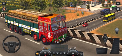 Truck Masters: India Simulator - Witness the vibrant artistry of a distinctively decorated truck, expertly hauling a heavy cargo of wooden logs along a wide highway.