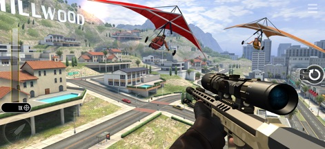 Pure Sniper: Gun Shooter Games - Esta captura muestra un escenario dinámico con ala delta surcando el cielo y el distintivo letrero "HILLWOOD" en la colina, añadiendo realismo al entorno.