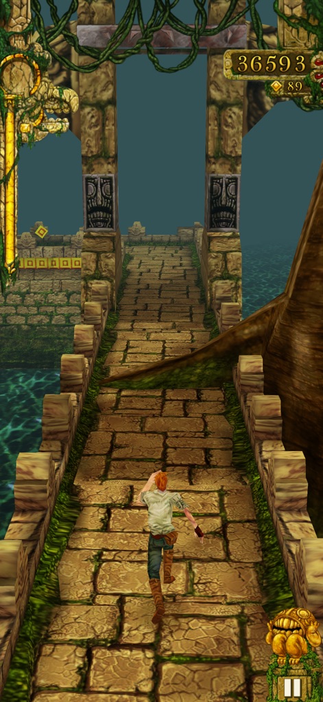 Temple Run - Die App präsentiert den Charakter auf dem Weg zu geheimnisvollen Torbögen, die mit gruseligen Gesichtern verziert sind und auf einem alten Pfad voller verfallener Architektur stehen.