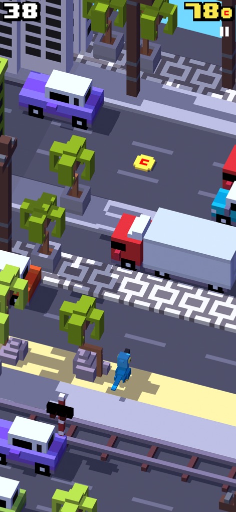 Crossy Road - La aplicación muestra un entorno urbano dinámico con palmeras y vehículos en movimiento, donde el personaje debe esquivar camiones y coches para sobrevivir.