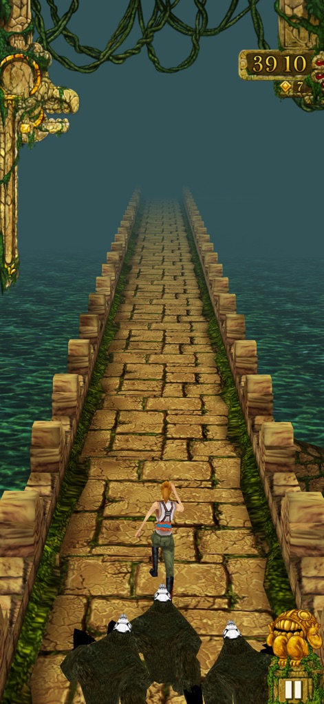 Temple Run - Nutzer erleben eine packende Verfolgungsjagd, bei der bedrohliche Dämonenaffen dicht hinter dem Charakter her sind, während dieser über eine alte Brücke eilt.