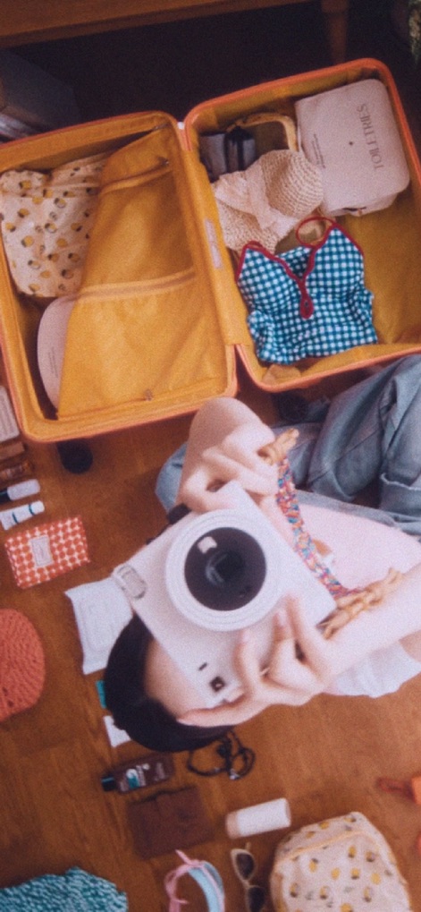 Jeju air - This image sets the scene for travel, showing an open suitcase brimming with essentials and a personal camera ready to capture memories.